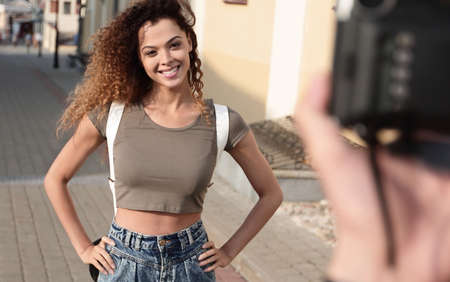Beautiful brown curly hair  woman posing in city