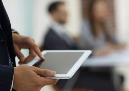 closeup.the man in the tablet on the background of the office