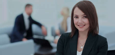 Successful business woman standing with her staff in background