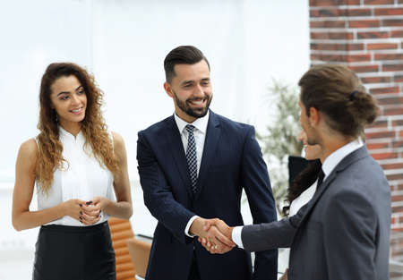handshake business partners in the office.