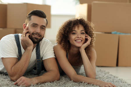 Portrait of a married couple lying on the floor after moving