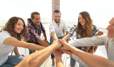 group of employees with hands clasped together.