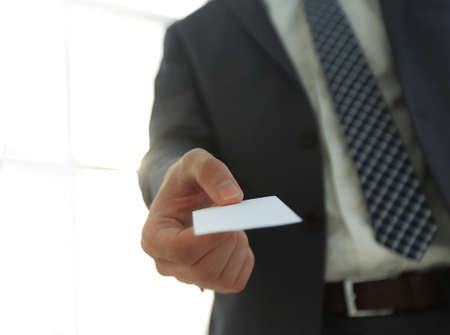 Business man giving business card on bright backgroundの写真素材