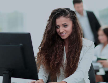 Young  businesswoman working in an office using computer with coの写真素材