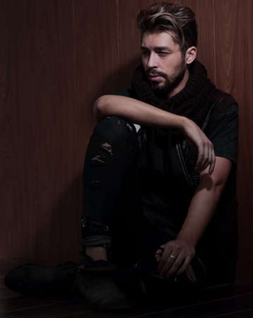 Portrait of young handsome fashionable man against wooden wall.の写真素材