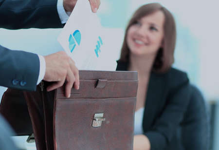 Cropped image of business woman getting documents out of briefcaの写真素材