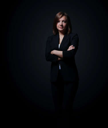 Full-length portrait of businesswoman isolated on black backgroundの写真素材
