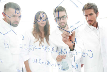 general-view seen trough a transparent board in a chemistry lab of people analyzing information
