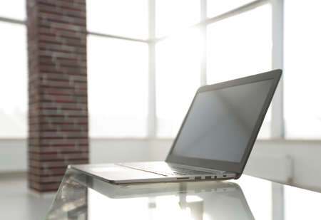 Office workplace with laptop on a glass table in a modern officeの写真素材