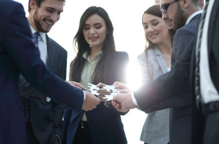 Group of business people assembling jigsaw puzzle, team supportの写真素材