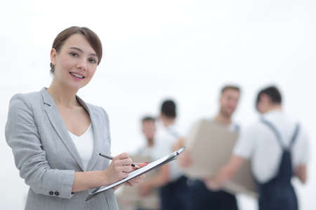 Woman manager holding clipboard on blurred background with moverの写真素材