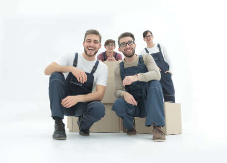 Smiling young delivery men holding stack of boxes. Isolated on wの写真素材