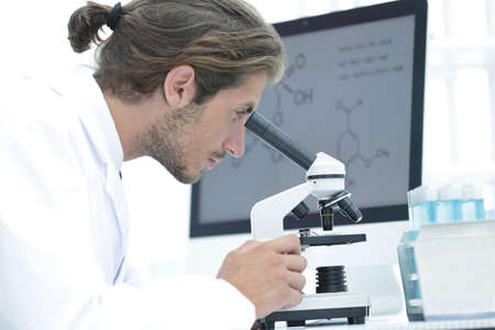senior lab technician using microscope in laboratory