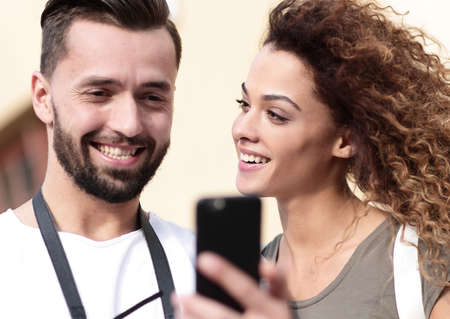 Happy young couple searching for location both on mobile phone