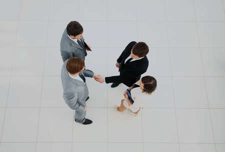 Business meeting. Top view of four people in formalwear standing close to each other while two of...