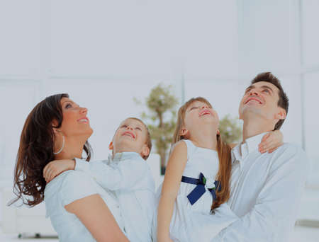 Happy family looking up and smiling.の写真素材