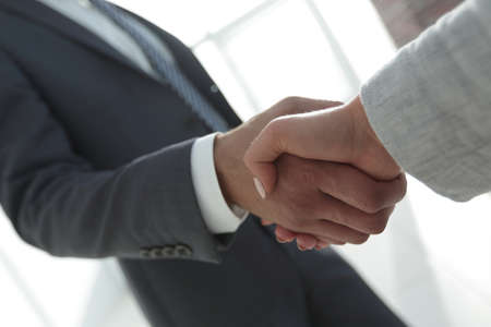 Excited smiling businessman handshaking partner at meeting,の写真素材