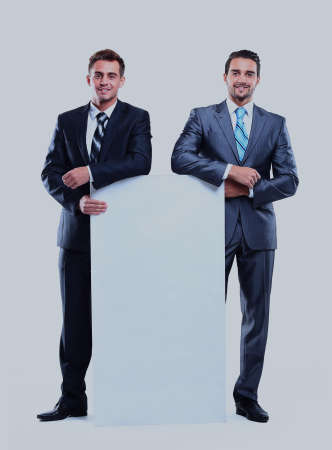 Two smiling business man showing blank signboard, isolated over white background.の写真素材