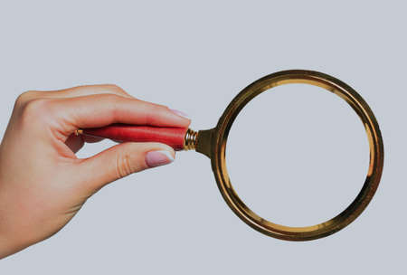 Magnifying glass in hand isolated on white backgroundの写真素材