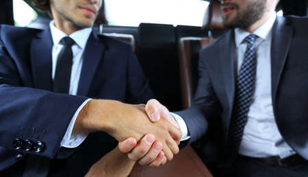 handshake of business partners sitting in the carの写真素材