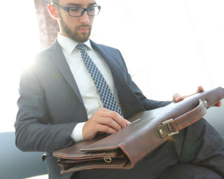 businessmans hand with suitecase in a modern officeの写真素材