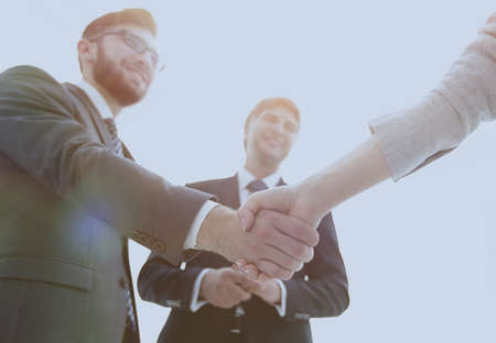 Business partners shaking hands in meeting hall