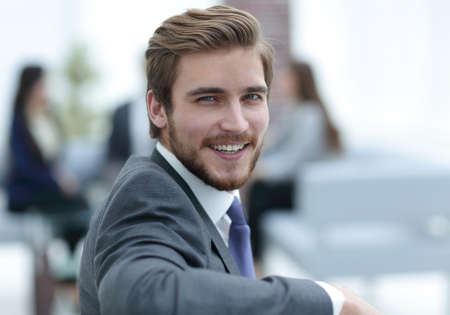 Successful business man standing with his staff in background at