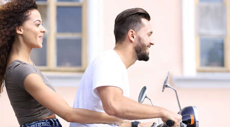 Cool man and beautiful girl riding on  scooter with  expression