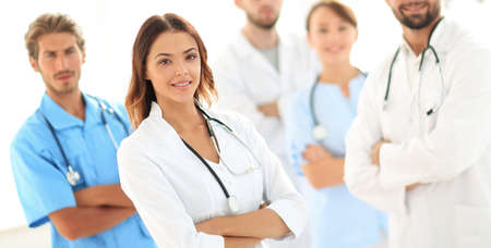Attractive female doctor with medical stethoscope in front of medical groupの写真素材