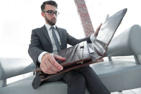 businessmans hand with suitecase in a modern officeの写真素材