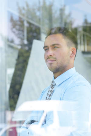 view from behind glass.confident businessman looking out the window of his office
