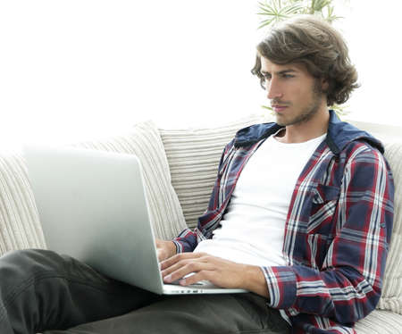 young man working on laptop sitting on couch