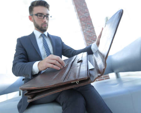 businessmans hand with suitecase in a modern officeの写真素材