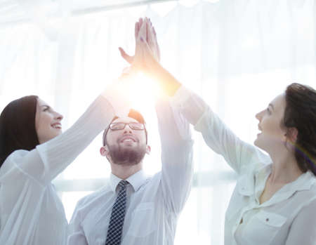 happy colleagues giving each other a high five