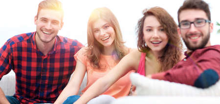 group of cheerful friends sitting on sofaの写真素材