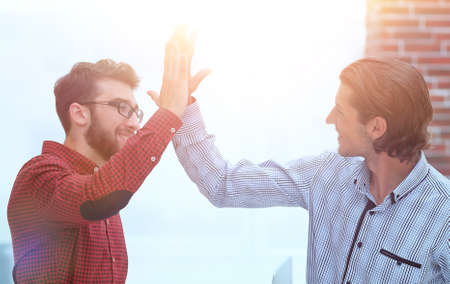 two colleagues giving each other high-fiveの写真素材