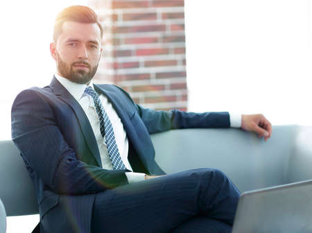 Portrait of a successful businessman sitting in the office lobby.