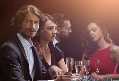 Poker players drink champagne on a black backgroundの写真素材