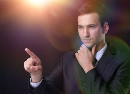 businessman pointing to a blank spot.isolated on a black background.の写真素材