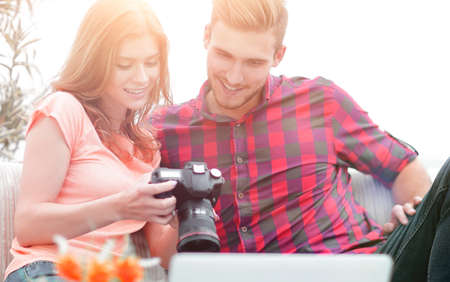young couple makes viewing photos in photo cameraの写真素材