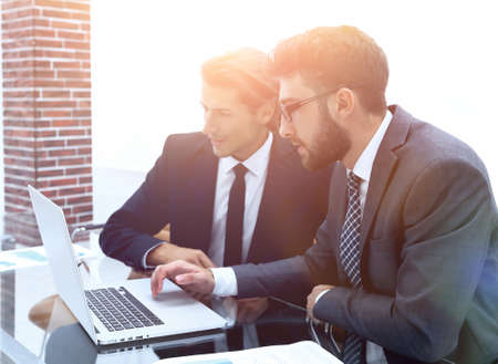 Two business men working on a laptopの写真素材
