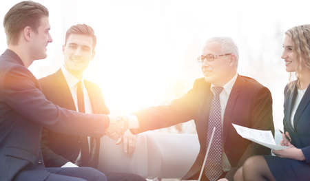 Partners concluding deal and shaking hands in the presence of teの写真素材