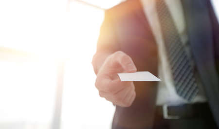 Business man giving business card on bright background