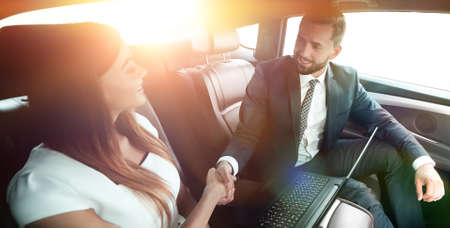 man and woman shaking hands in car