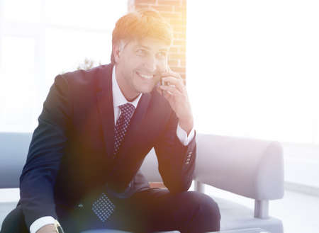 businessman talking on smartphone in officeの写真素材