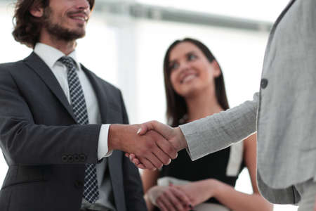 Businesspeople  shaking hands against room with large window looの写真素材