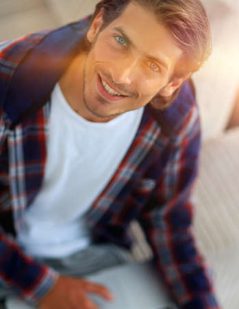 young man working on laptop and looking at camera. view from aboveの写真素材