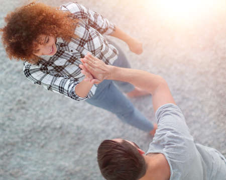 young couple give each other five in new living roomの写真素材