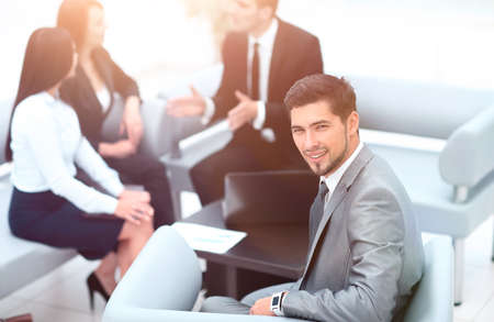 businessman sitting in an office on the background of business team.の写真素材