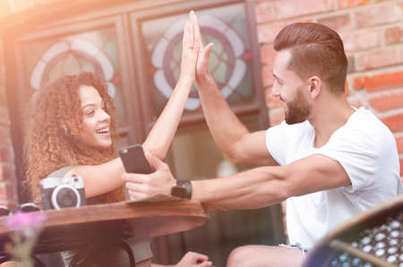 Portrait of a young  couple sitting down at a cafe terrace
